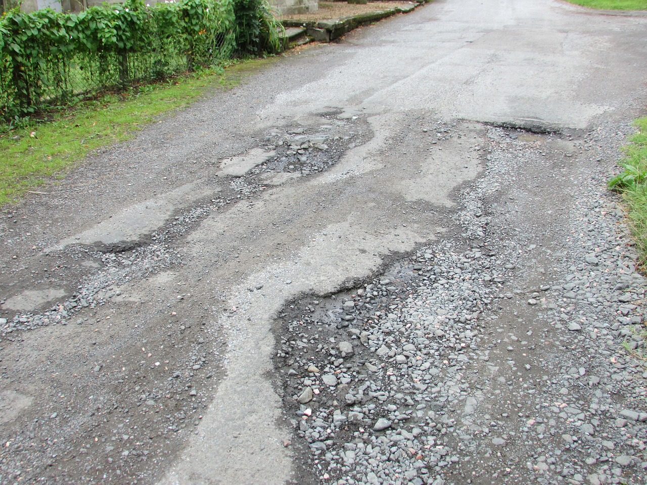 Pothole-damaged road on NE 199th St — construction zone tire hazards in Aventura